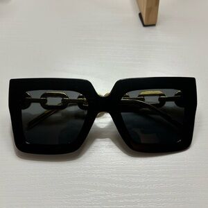 Women’s oversized black and gold sunglasses